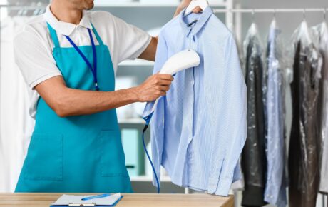 A dry cleaner drying a shirt