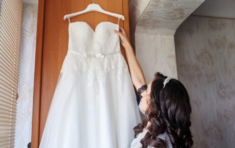 A bride hanging up her wedding gown after the wedding